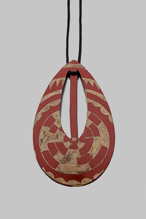 Jean DUNAND - Pendentif en laque à décor de motifs géométriques dorés sur fond rouge. Signé Jean Dunand. Dimensions : 10,5 x 6 cm